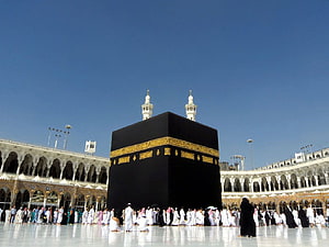 The Sacred Kaaba in Mecca with Pilgrims Performing Tawaf Under a Clear Blue Sky HD wallpaper