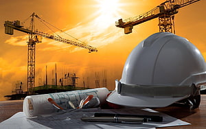 Construction Site Safety Concept with Hard Hat and Blueprints at Sunset HD wallpaper