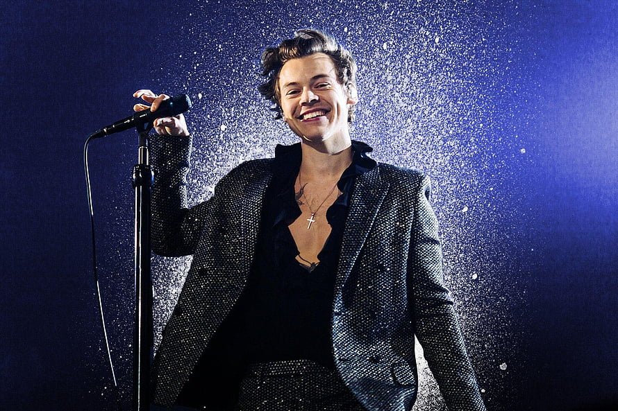 Harry Styles performing on stage in a sparkling suit with confetti and blue lighting HD wallpaper