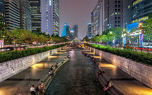 Cheonggyecheon Stream at Dusk in Seoul with City Skyline and Pedestrians HD wallpaper
