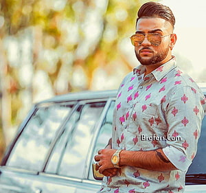 Karan Aujla in a patterned shirt and sunglasses standing beside a car HD wallpaper