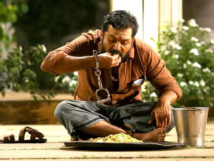 Karthi as Kaithi in dramatic prison meal scene with handcuffs and banana leaf plate HD wallpaper