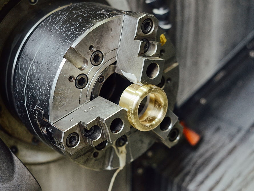 Close-Up of CNC Lathe Machining a Brass Component in a Precision Metalworking Shop HD wallpaper