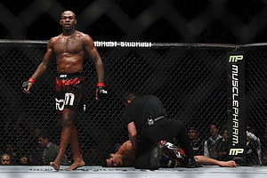 Jon Jones standing victorious in the UFC octagon after a knockout finish HD wallpaper