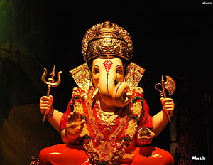 Ornate Lord Ganesha Statue Adorned in Red Garments and Gold Jewelry Against a Dark Backdrop HD wallpaper