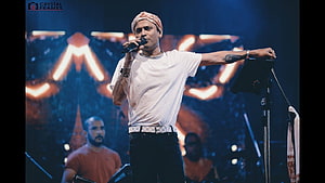 Zubeen Garg performing live on stage with microphone and turban HD wallpaper