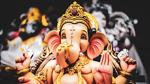 Lord Ganesha Murti with Golden Crown and Ornate Jewelry in Temple Setting HD wallpaper
