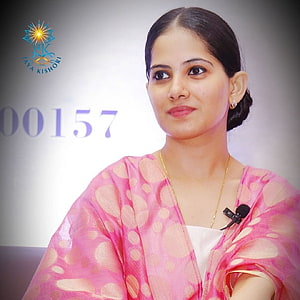 Jaya Kishori in a pink patterned dupatta with a gold necklace and microphone at a public event HD phone wallpaper
