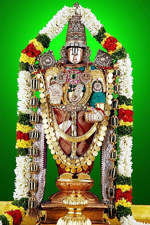 Ornate Venkateswara Swamy deity statue adorned with gold jewelry and vibrant flower garlands HD phone wallpaper