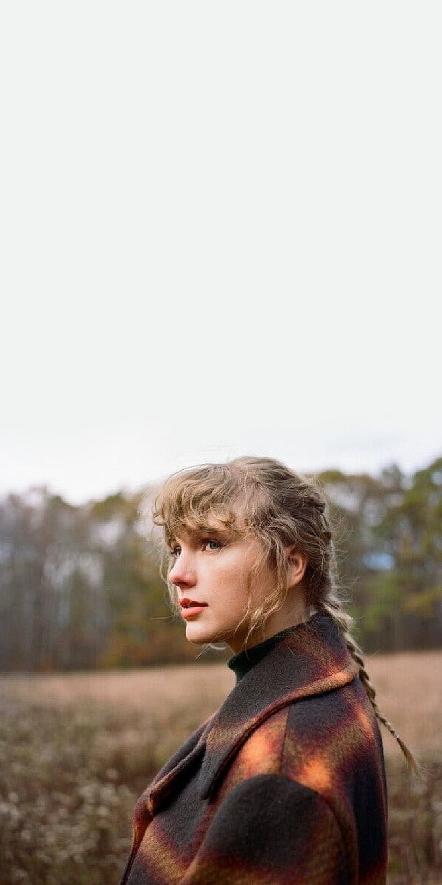 Taylor Swift in a plaid coat standing in a field with braided hair and a serene expression HD phone wallpaper