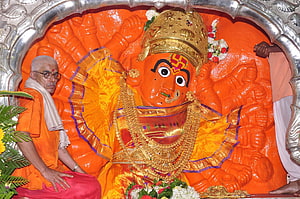 Saptashrungi Ganesha Murti with Priest in Orange Saffron Attire HD wallpaper