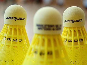 Close-up of three yellow Carlsbad badminton shuttlecocks with cork heads and plastic skirts HD wallpaper