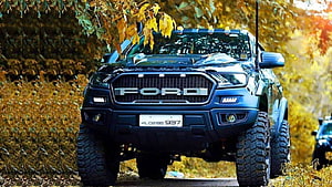 Black Ford Endeavour SUV with Off-Road Tires in Autumn Forest Setting HD wallpaper