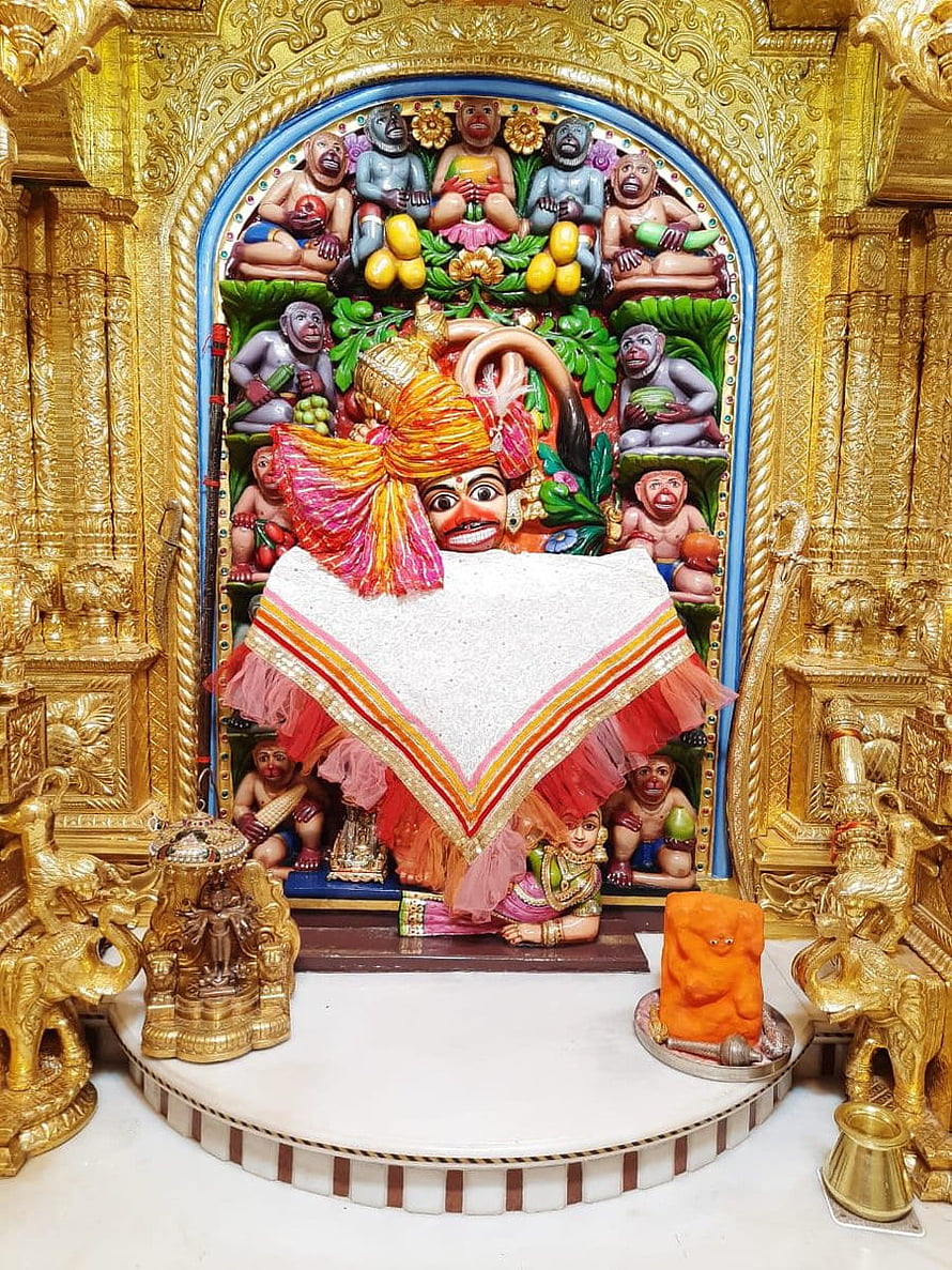 Hanuman Temple Shrine with Golden Carvings and Devotional Offerings HD phone wallpaper