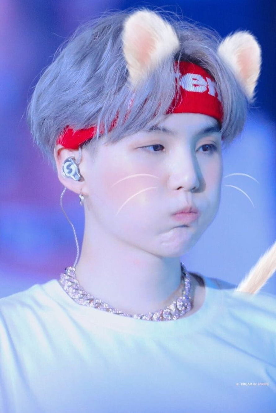 Suga of BTS in a playful cat costume with red headband and whiskers on stage HD phone wallpaper