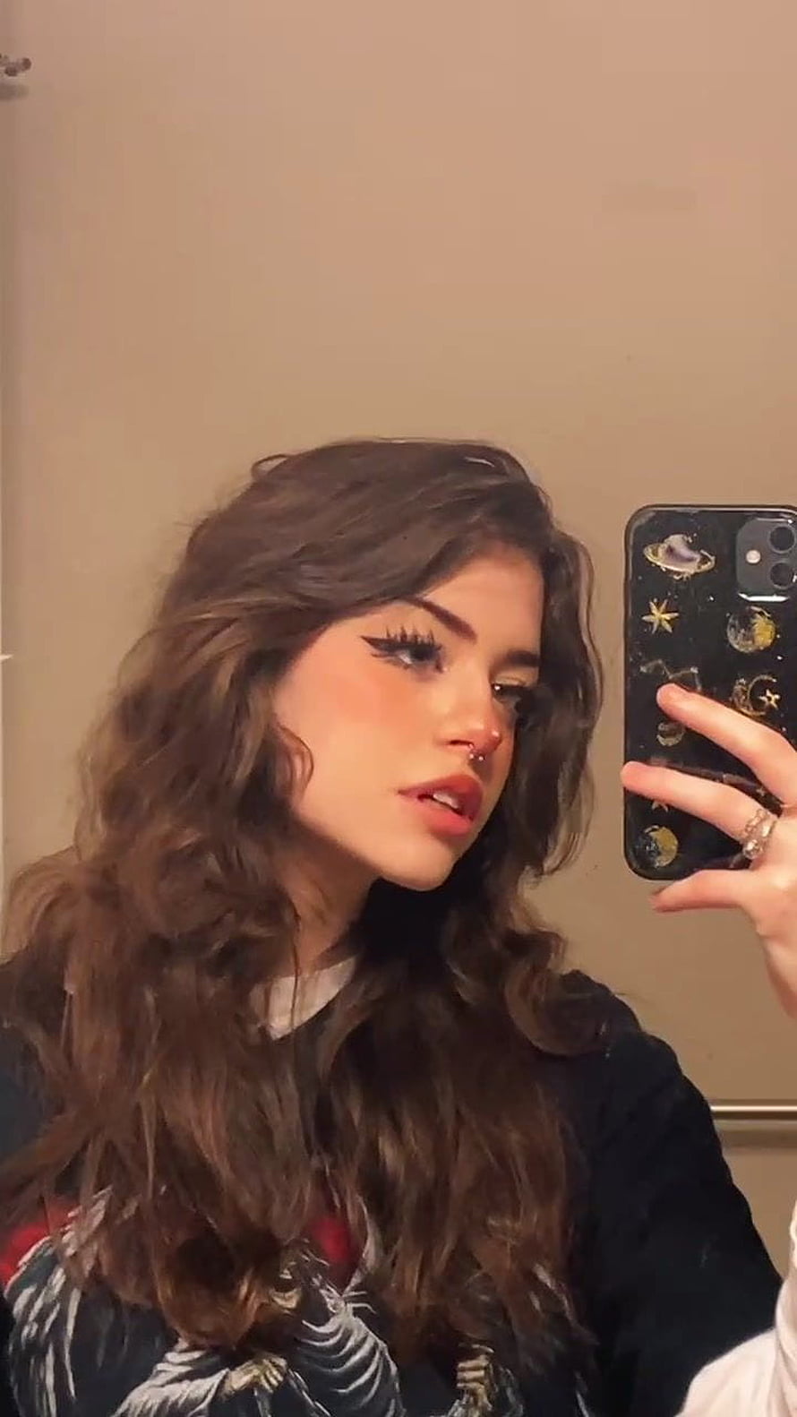 Young woman with long wavy brown hair taking a mirror selfie with a celestial phone case HD phone wallpaper