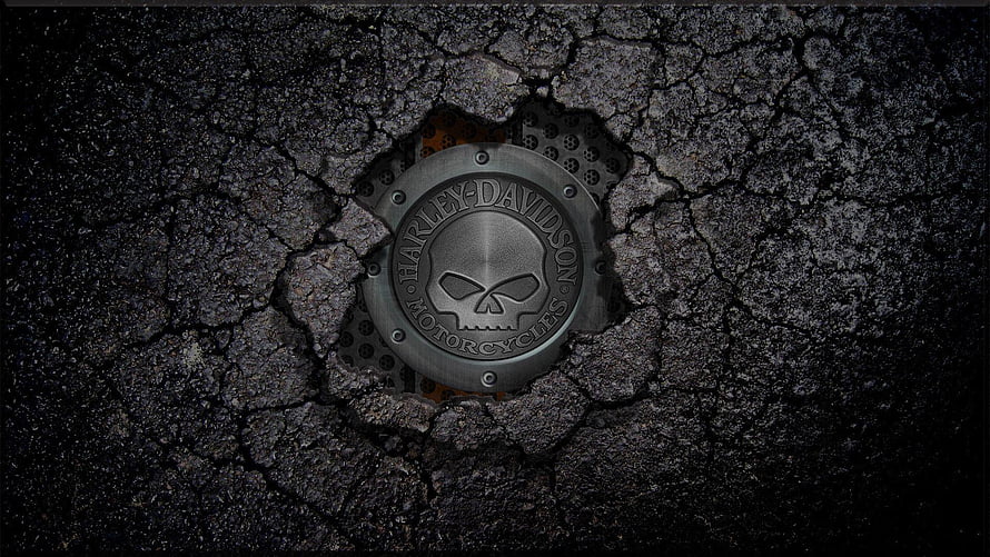 Harley-Davidson Skull Emblem Embedded in Cracked Black Asphalt Surface HD wallpaper