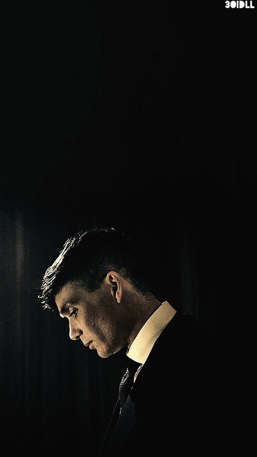 Thomas Shelby in a dark suit with a white collar, captured in a moody, low-light profile portrait HD phone wallpaper