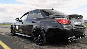 Black BMW E60 M5 Sedan Rear Three-Quarter View on Asphalt Track HD wallpaper