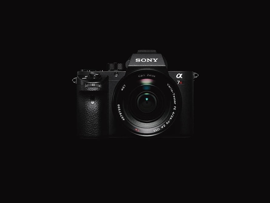 Sony Alpha 7R II Mirrorless Camera with Carl Zeiss Vario-Tessar Lens on Black Background HD wallpaper