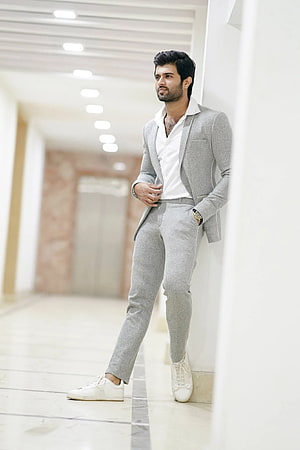 Vijay Devarakonda in a Light Grey Suit and White Sneakers Leaning Against a Wall HD phone wallpaper