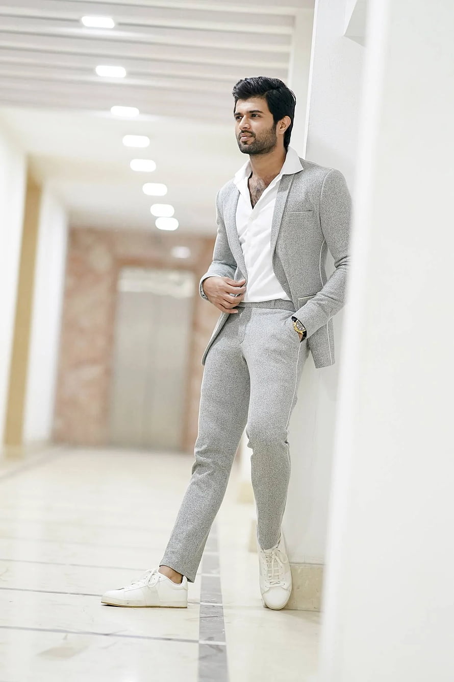 Vijay Devarakonda in a Light Grey Suit and White Sneakers Leaning Against a Wall HD phone wallpaper