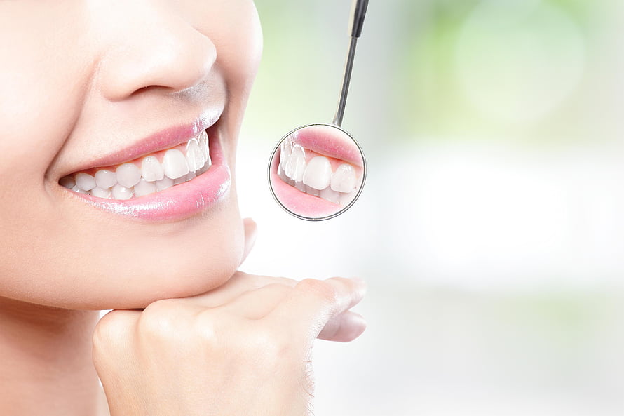 Close-up of a bright smile with a dental mirror reflecting healthy white teeth HD wallpaper