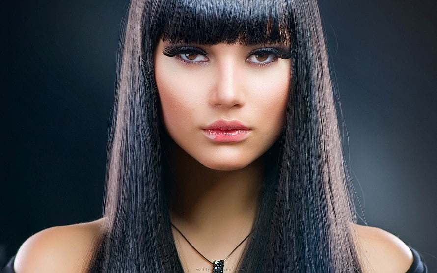 Close-up portrait of a woman with long straight black hair and blunt bangs against a dark background HD wallpaper