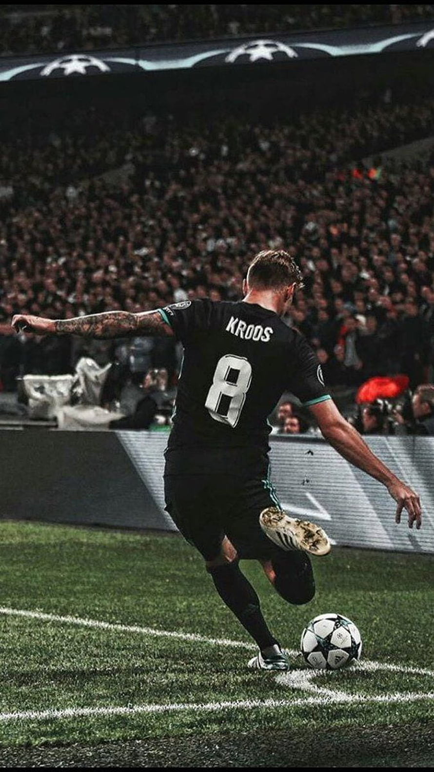 Toni Kroos in black Real Madrid kit striking the ball during a UEFA Champions League match HD phone wallpaper