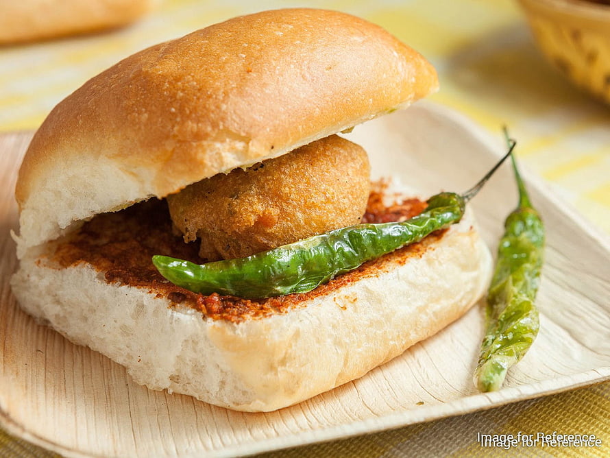 Vada Pav Street Food Sandwich with Fried Potato Fritter and Green Chilies on a Wooden Plate HD wallpaper