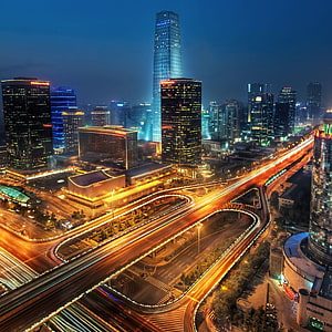 Aerial Night View of a Modern Asian City Skyline with Glowing Highway Interchange and Skyscrapers HD phone wallpaper