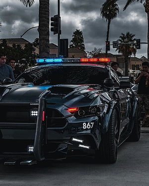 Black Ford Mustang Police Interceptor with Active Light Bar on Urban Street HD phone wallpaper