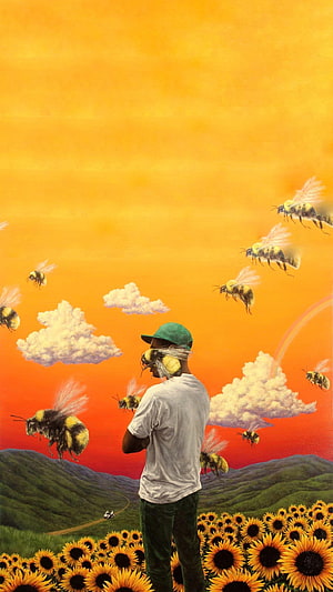 Tyler the Creator in a Surreal Sunflower Field with Giant Bees and a Vibrant Sunset Sky HD phone wallpaper