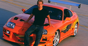 Paul Walker Leaning on Orange Toyota Supra MK4 with Blue Rear Wing HD wallpaper