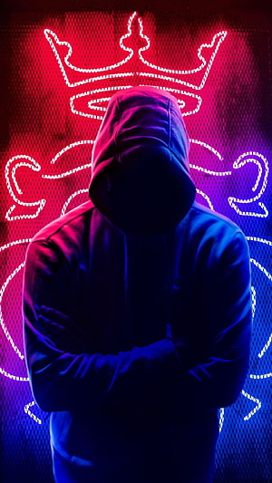 Mysterious Hooded Figure Silhouette Against Neon Crown LED Wall HD phone wallpaper