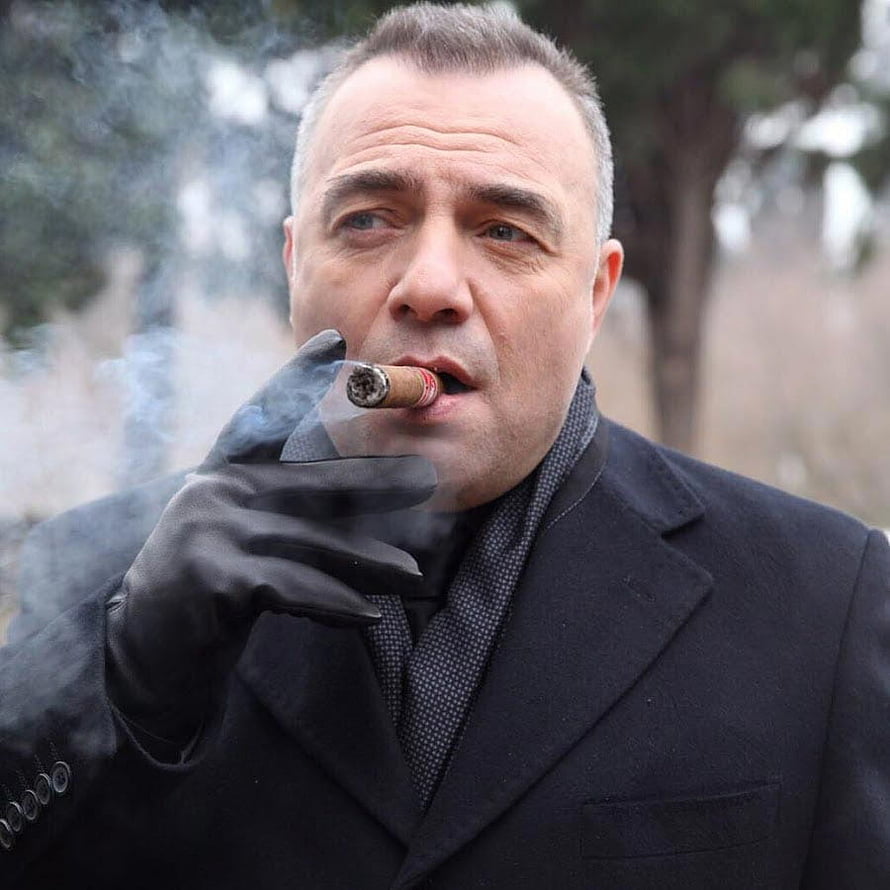 Oktay Kaynarca as Suleyman Cakir smoking a cigar in a dark coat and black gloves HD phone wallpaper