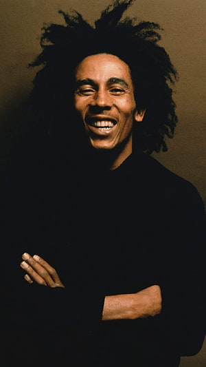 Bob Marley smiling portrait with dreadlocks and crossed arms in black shirt HD phone wallpaper