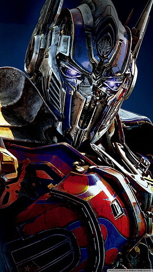 Transformers Optimus Prime Close-Up Portrait with Glowing Blue Eyes and Weathered Armor HD phone wallpaper