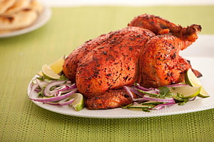 Spiced Tandoori Roast Chicken with Sliced Red Onions, Lime Wedges, and Fresh Cilantro on a White Plate HD wallpaper