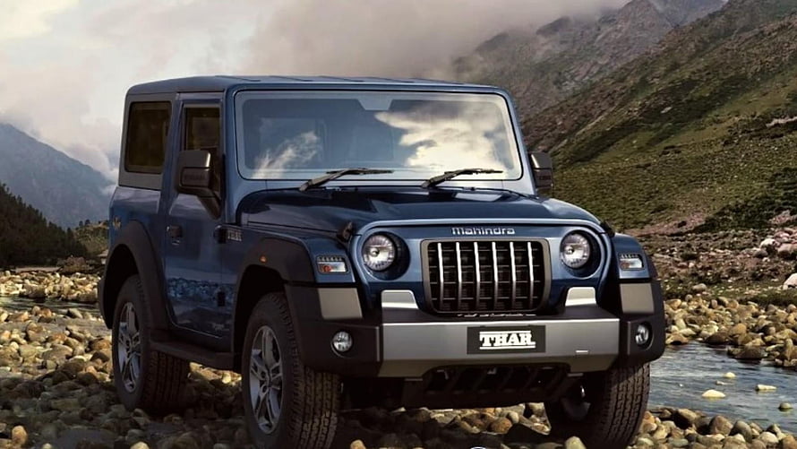 Mahindra Thar SUV parked on rocky riverbed with misty mountain backdrop HD wallpaper
