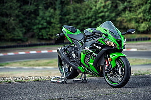 Kawasaki Ninja ZX-10R sportbike in green and black parked on a racetrack HD wallpaper