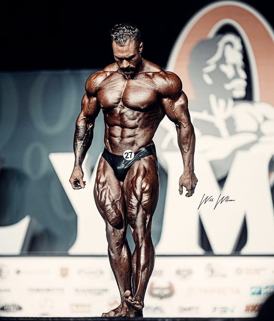Chris Bumstead Bodybuilder Stage Pose with Extreme Muscle Definition and Vascularity HD phone wallpaper