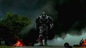 Transformers Lockdown Walking Through Smoke and Fire on a Dark Road HD wallpaper