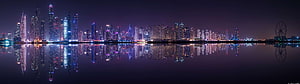 Panoramic Night Skyline with City Lights Reflected in Calm Water HD wallpaper