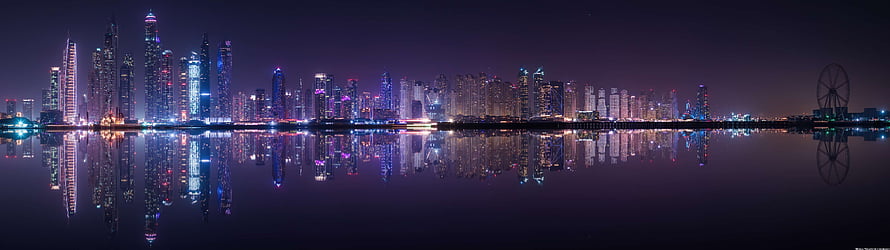 Panoramic Night Skyline with City Lights Reflected in Calm Water HD wallpaper