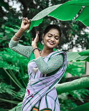 Santali Woman in Traditional Saree Holding Banana Leaf in Lush Green Garden HD phone wallpaper