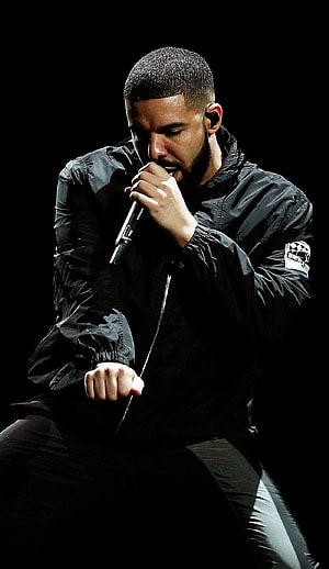 Drake performing live on stage in a black jacket holding a microphone HD phone wallpaper