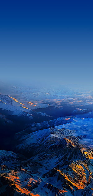Aerial View of Snow-Capped Mountain Ranges at Golden Hour with Deep Blue Sky HD phone wallpaper