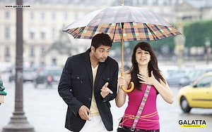 Engeyum Kadhal Movie Still Featuring Couple Walking Under Plaid Umbrella in City Square HD wallpaper