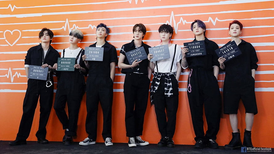BTS Members in Black Outfits Holding Police Department Signs Against Orange ECG Background HD wallpaper